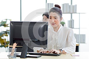 Portrait shot of Millennial Asian young professional successful female businesswoman secretary sitting smiling looking at camera