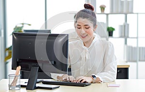 Portrait shot of Millennial Asian young professional successful female businesswoman secretary sitting smiling looking at camera