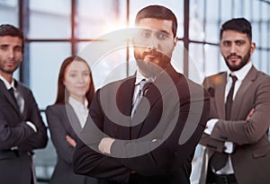 portrait shot of smiling business team of four standing and smiling at camera against a modern office background