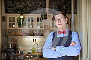 Small business owner standing in the cafe entrance while wating for guest