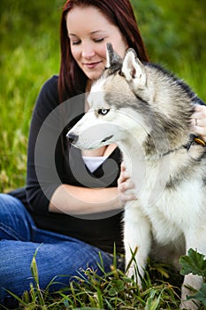 Portrait of a Siberian Husky dog outdoors and a girl