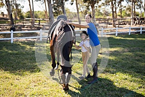 Portrait of siblings standing by horse