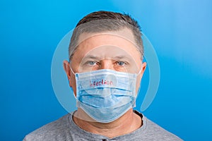 Portrait of a sick man wearing medical mask with infection text at blue background. concept. Protect your health