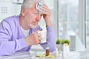 Portrait of sick senior man with pills posing
