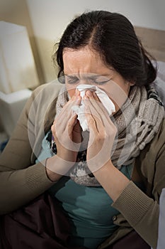 Portrait of sick woman blowing her nose