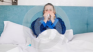 Portrait of sick woman with cold blowing ner runny nose