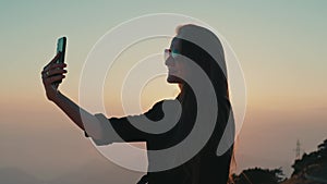 Portrait silhouette of young woman standing on viewpoint on top of mountain