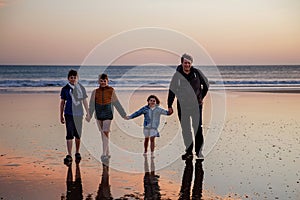 Portrait silhouettes of three children and dad happy kids with father on beach at sunset. happy family, Man, two school