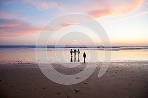Portrait silhouettes of three children and mum happy kids with mother on beach at sunset. happy family, woman, two
