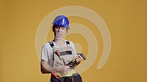 Portrait of silly contractor playing air guitar with hammer