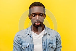 Portrait of silly funny positive man crossing eyes looking at his nose. indoor studio shot isolated on yellow background