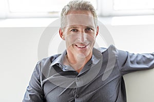 Portrait of single 40s man sitting in sofa