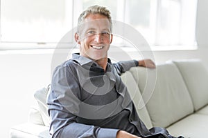 Portrait of single 40s man sitting in sofa