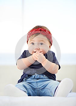 Portrait, sitting and bed for baby fashion in family home, cute and trendy street style on curious girl toddler