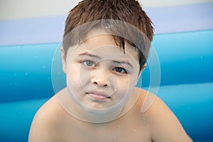 Portrait. a six-year-old boy in a children`s inflatable pool. selective focus. low focus depth
