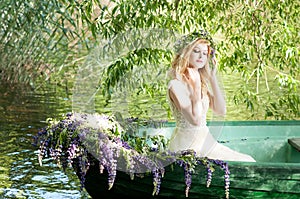 Portrait of slavic or baltic woman with wreath sitting in boat with flowers. Summer