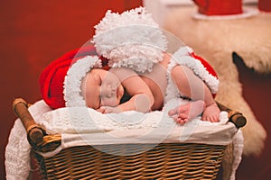 Portrait of sleeping newborn baby boy in Santa clothes.