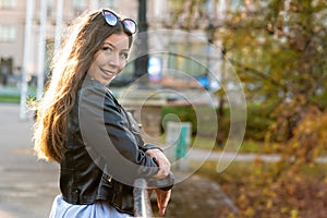 portrait of an slim emotional dark-haired teenager woman in a city park on a sunny day photo