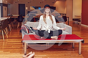 Portrait of slim fit sporty young white Caucasian business woman meditating doing yoga exercises