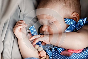 Portrait of slipping cute adorable baby girl in blue polka dot dress