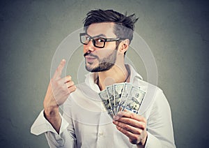Portrait of a sly business man with hundred dollar bills giving one piece of advice photo