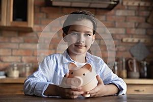 Portrait of small boy child hold piggybank