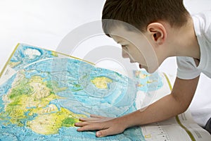 Portrait of small boy studying the map of the world
