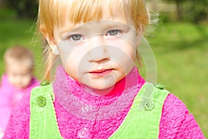 Portrait small girl on green herb by autumn