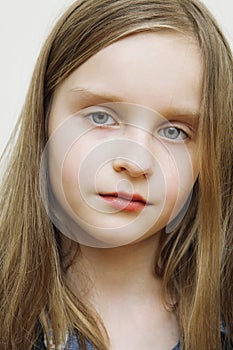 Portrait of small happy girl with long blond hair.