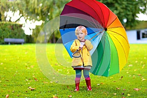 Portrait of small preschooler girl with colorful umbrella