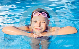 Portrait of a small smiling girl in a garden pool