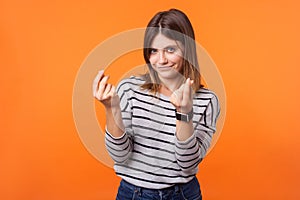 Portrait of smart beautiful woman with brown hair in long sleeve striped shirt. indoor studio shot isolated on orange background