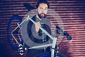 Portrait of smart confident man with bicycle smoking pipe