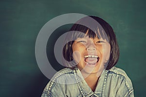 Portrait of smart girl by the blackboard happy laugh