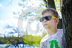 Portrait of smart little boy wearing sunglasses smirking.