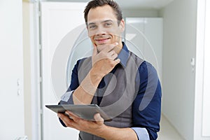 portrait smart man holding tablet hand on chin