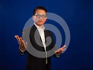 Portrait of smart middle-aged asian confident successful businessman wearing suit with welcoming gesture