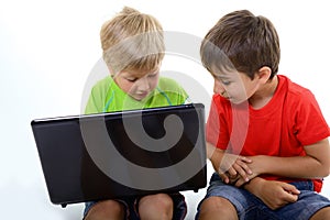 Portrait of smart schoolboys looking at the laptop, over white photo