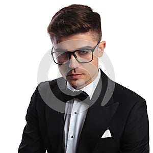 Portrait of smart young man wearing black tuxedo and glasses