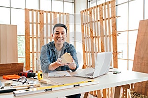 Portrait of a smile Asian male father sitting and working with a laptop on the table with the instrument of measure and working