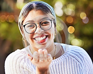 Portrait, smile and blowing a kiss with a woman on a nature green background for love or romance. Face, glasses and