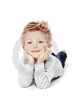 Portrait, smile and boy lying down, relax and cheerful kid isolated against white studio background. Face, male child or