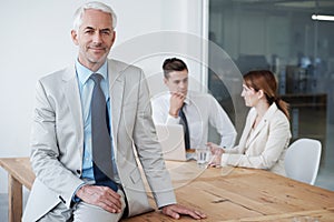 Portrait, smile and business man on table in boardroom of office for meeting, planning or management. Leadership