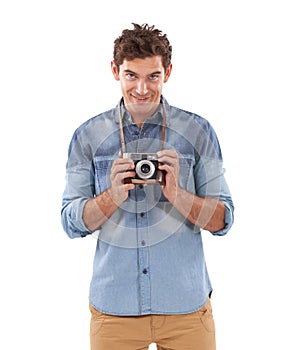 Portrait, smile and camera with a photographer man in studio isolated on a white background for a hobby. Creative