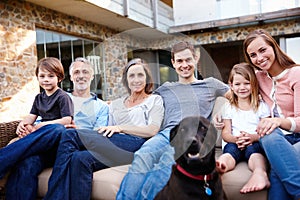 Portrait, smile and family at house with dog outdoor together on sofa for love and bonding at backyard. Home, parents