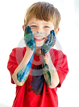 Portrait, smile and paint with a creative boy in studio isolated on a white background for art or education. Face, hands