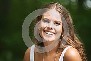 Portrait, smile and a woman in the forest on a green background for freedom, travel or to relax. Face, beauty and a