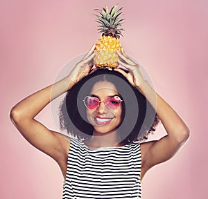 Portrait, smile and woman with pineapple, glasses and fashion with confidence on pink studio background. Face, person