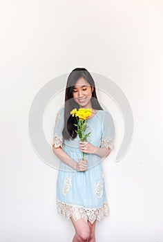 Portrait of smilimg asian girl holding bouquet with yelliow flowers with copyspace