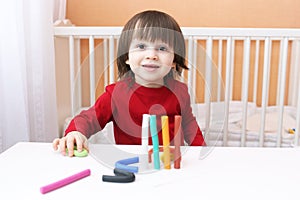 Portrait of smiling 2 years child with playdough